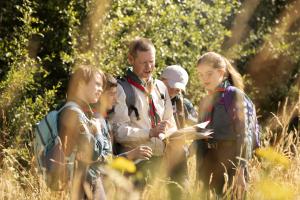 Vier Kinder und ein Mann bei einer Wanderung im Wald