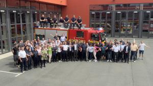 Viele Menschen vor einem Feuerwehr-Auto