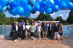 Gruppenfoto geladender Gäste vor Schwimbecken