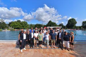 Gruppenfoto geladender Gäste vor Schwimbecken