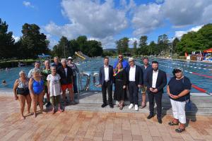 Gruppenfoto geladender Gäste vor Schwimbecken