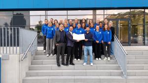 Menschen stehen auf einer Treppe, im Hintergrund ist das Stadion, zwei Personen halten das Goldene Buch der Stadt Jena aufgeklappt