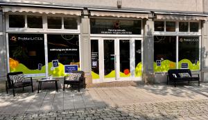 Bild zeigt einen Laden mit großen Fenstern und Sofas davor. Es ist der ProbierLaden Jena.