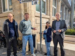 Menschen vor einem Mülleimer mit Pfandringen