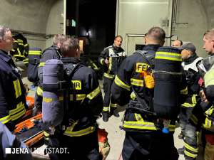 Feuerwehrleute stehen im Kreis und reden miteinander.