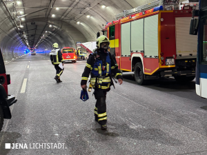 Ein Feuerwehrmannläuft mit Atemschutzmaske durch den Tunnel.