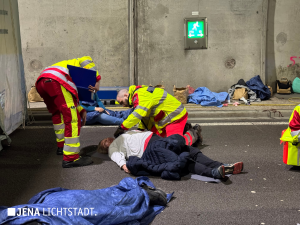 Zwei Sanitäter kümmern sich um eine verletzte Frau.