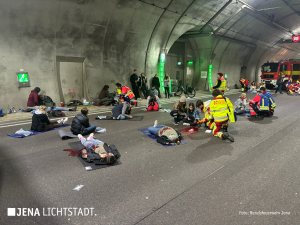 Geborgene verletzte Personen liegen im Tunnel und werden von Sanitätern versorgt.