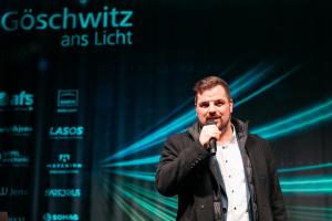 Kulturdezernent Johannes Schleußner hält ein Mikrofon in der Hand und spricht.