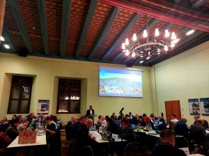 Der Stadtrat tagt im Historischen Rathaus, Menschen sitzen an Tischen, der Oberbürgermeister spricht am Rednerpult