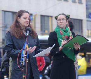 Zwei Frauen auf einer Demonstration, eine redet ins Mikrophon