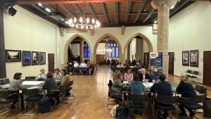 Ein großer Raum mit Tischen und Menschen gefüllt