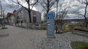 Eine Stele mit Informationen zu Robert J. Büchler und dem Todesmarsch am 11. April 1945 steht auf einem Gehweg. Im Hintergrund ist ein Schulgebäude zu sehen.