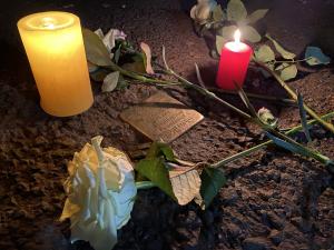 Blumen und Kerzen neben einem Stolperstein
