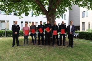 Feuerwehrmänner und OB schauen in die Kamera.