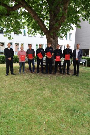 Feuerwehrmänner und OB schauen in die Kamera.