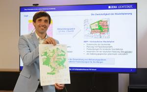 Mann hält eine Landkarte in die Kamera.