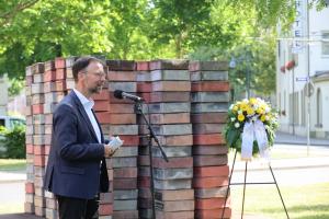 Ein Mann steht vor einem Denkmal.