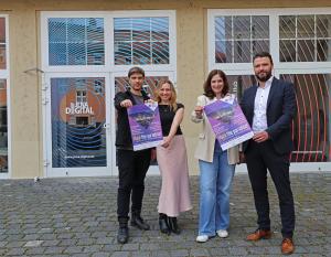 Zwei Männer und zwei Frauen zeigen Plakate