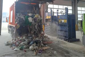 Ein Müllfahrzeug entleert in einer Halle den eingesammelten Hausmüll.