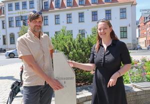 Zwei Personen an einem Trinkwasserbrunnen