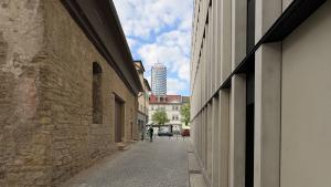 Ein Durchgang – links ein mittelalterliches Gebäude, rechts ein modernes Gebäude