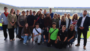 Viele Menschen schauen in der Fußballarena in die Kamera.