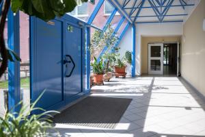 Glasgang mit einer großen blauen Tür im Vordergrund