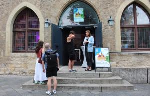 Vier Personen stehen am Eingang vor der Ratszeise in Jena.