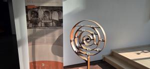 Eine Informationsstele informiert über die NS-Zeit. Daneben steht ein Kerzenständer mit mehreren Teelichtern.