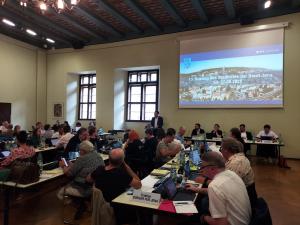 Stadtratsmitglieder im Rathaus sitzen an Tischen, Oberbürgermeister Dr. Thomas Nitzsche spricht am Rednerpult