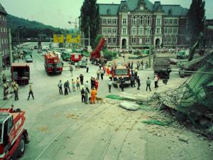 Menschen schauen auf ein eingestürztes Gebäude.
