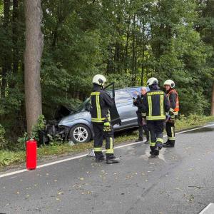 Polizei und Feuerwehr steht um einen Unfallwagen herum.