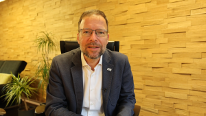 Ein Mann sitzt auf einem Stuhl und schaut in die Kamera