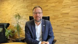 Ein Mann sitzt auf einem Stuhl und schaut in die Kamera