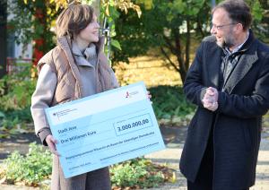 Die Ostbeauftragte Elisabeth Kaiser übergibt Oberbürgermeister Thomas Nitzsche einen Fördermittelscheck.