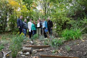 Gruppenbild: acht Personen. Eine Frau hält eine Urkunde in der Hand