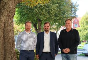 Drei Personen stehen nebeneinander