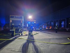 Feuerwehrautos und -leute arbeiten auf einem großen Platz.