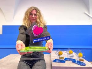 StadtLab-Projektmanagerin Grit Sachse präsentiert einen der Pokale für den StadtLab Ideenwettbewerb 2025.