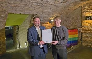 Zwei Personen halten ein Dokument in der Hand. 