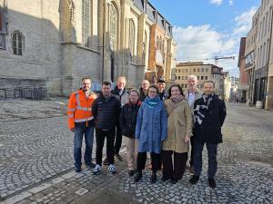 Mehrere Menschen stehen auf dem Kirchplatz in Jena und schauen in die Kamera.