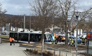 Eine Straßenbahn steht mit gesprungener Frontscheibe auf den Gleisen. Mehrere Rettungskräfte sind vor Ort.