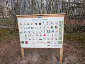 Eine Tafel mit 66 leicht verständlichen Symbolen können Wünsche, Bedürfnisse oder Gefühle gezeigt werden auf einem Spielplatz.