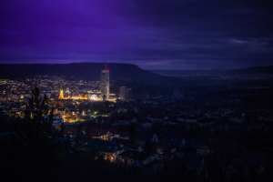 Panorama von Jena bei Nacht. Die eine Hälfte Jena ist dunkel.