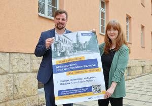 Zwei Personen halten ein Plakat 