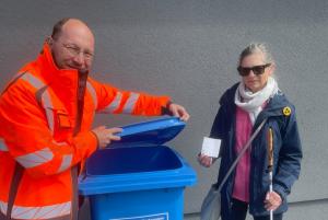 Martin Steglitz und Beatrix Adloff haben den ersten Aufkleber auf einer blauen Tonne angebracht.