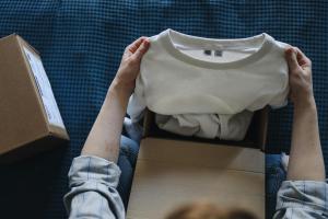 Person hält T-Shirt in der Hand.