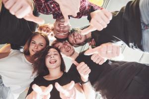Junge Menschen stehen im Kreis und haben Spaß