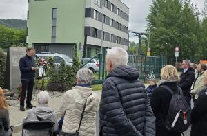 Oberbürgermeister Dr. Thomas Nitzsche steht an einem Mikrofon vor einer Gedenkstele, neben ihm ist ein Kranz aufgebaut, im Vordergrund stehen Zuhörerinnen und Zuhörer.
